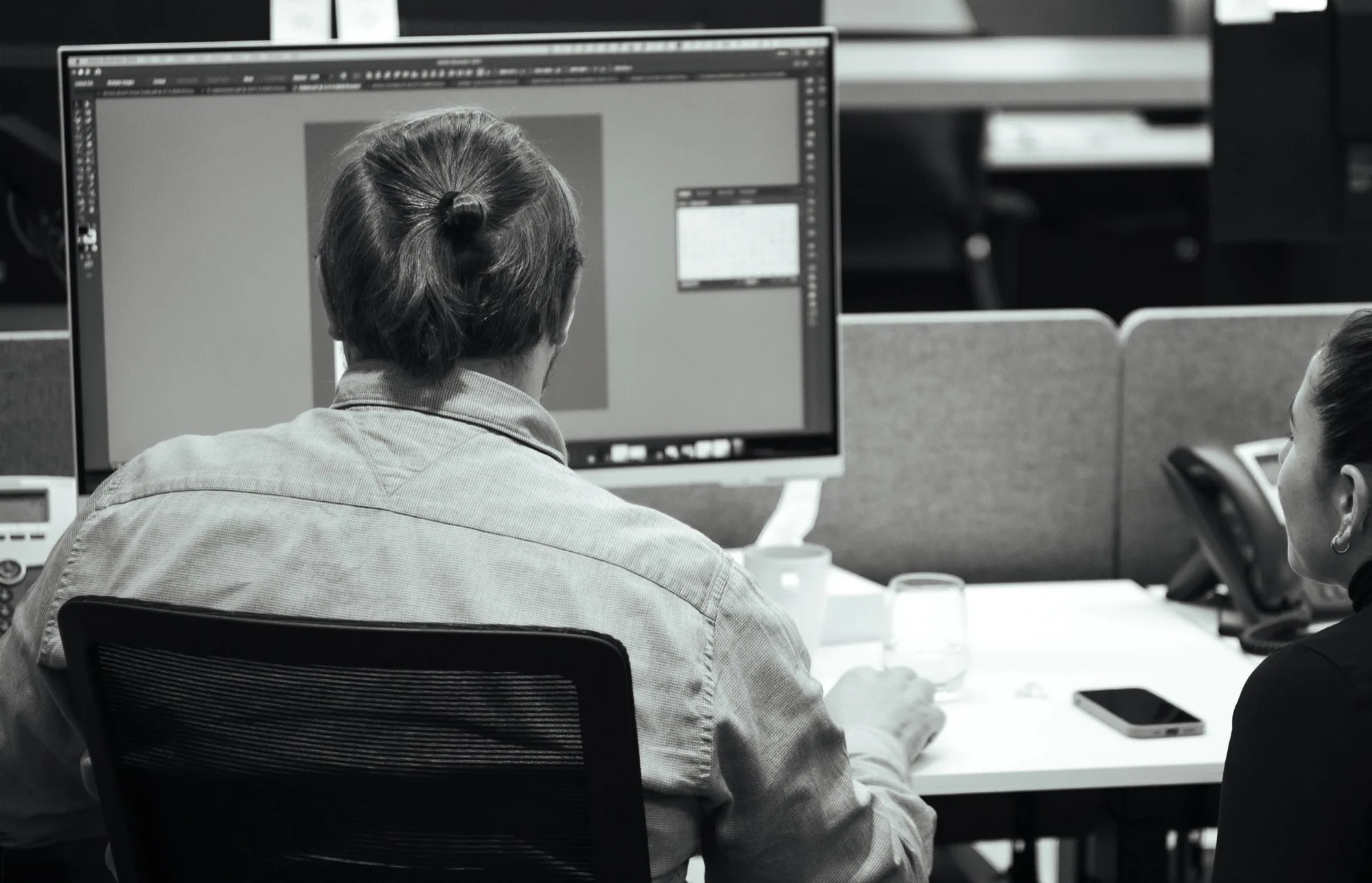 Jason Lewis reviewing design work on a desktop screen